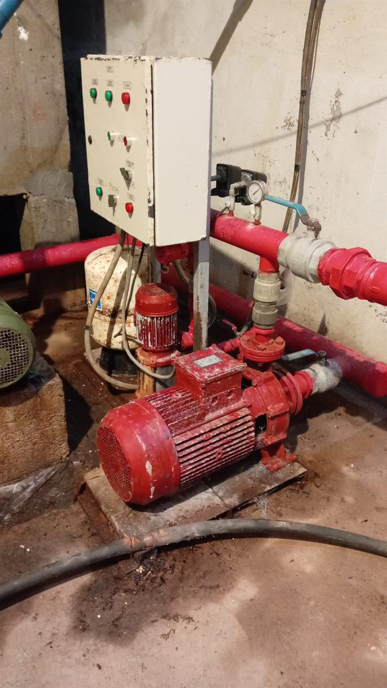 Sala de bombas contra incendios con óxido en el piso, bombas y cañerías