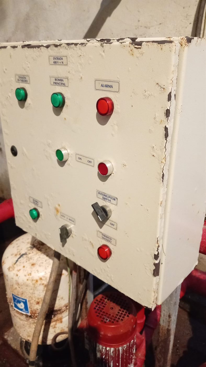 Tablero eléctrico de bombas contra incendios con pintura descascarada y óxido